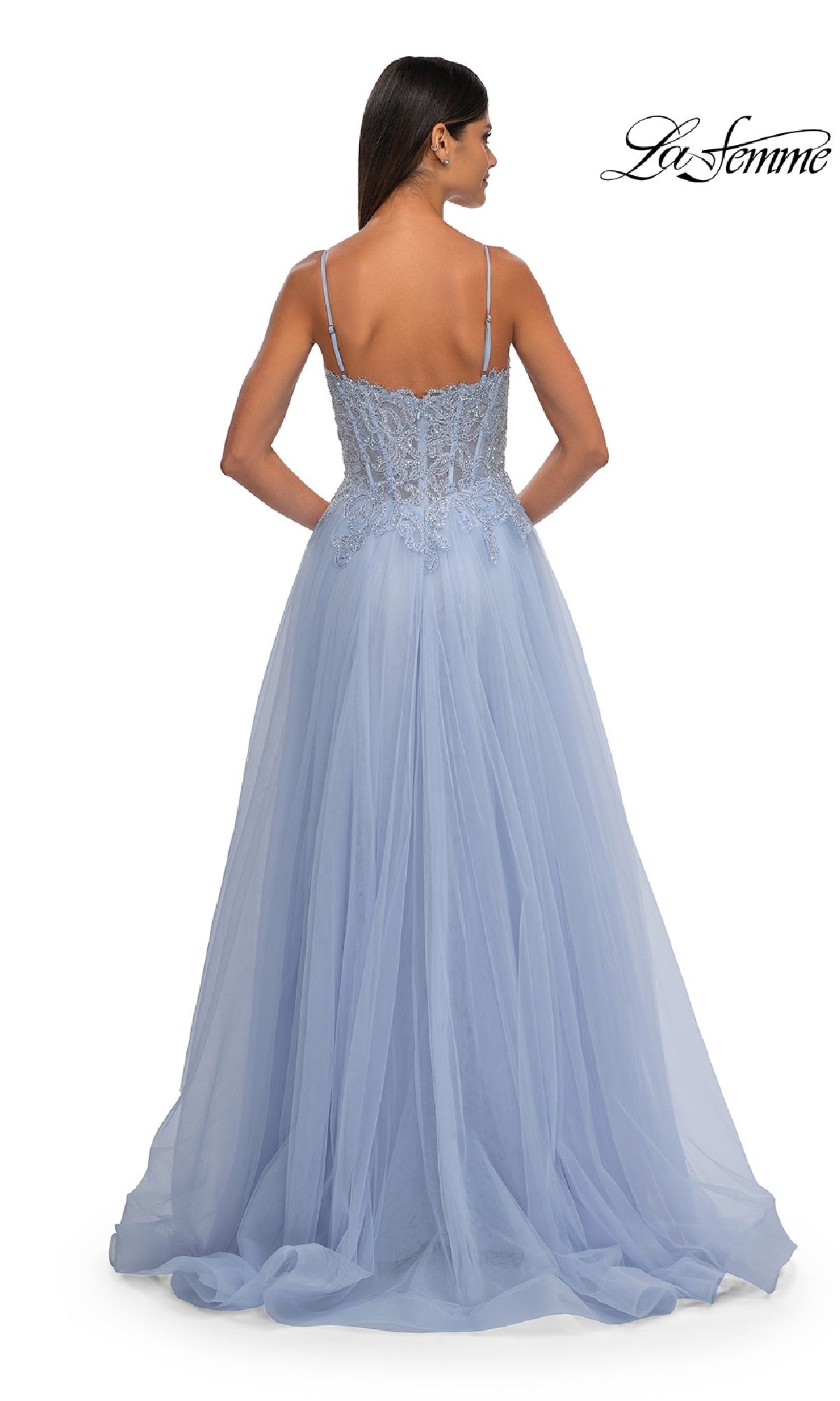 A woman is seen from behind in the La Femme 32646 Long Prom Ball Gown with Pockets, featuring thin straps, lace bodice detailing, and a flowing light blue tulle skirt—perfect for making an entrance at any event.