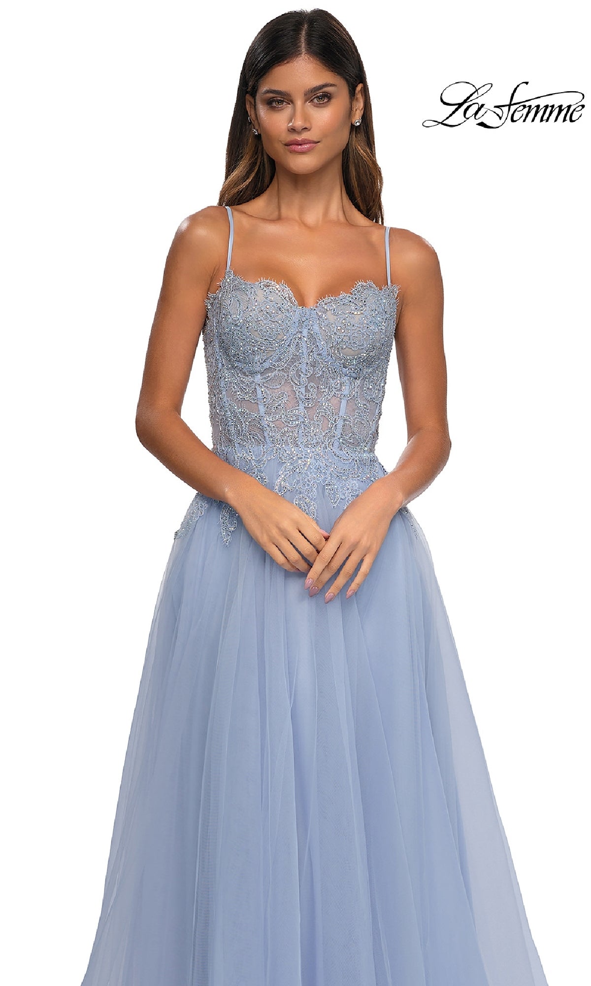 Woman wearing the Long Prom Ball Gown with Pockets, La Femme 32646—a light blue dress with lace details, thin straps, and a flowing tulle skirt—poses against a white background with the 
