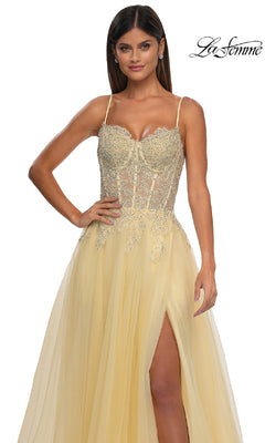 Woman wearing the La Femme 32646 long prom ball gown with pockets, featuring a yellow embellished design, sheer beaded bodice, spaghetti straps, and thigh-high slit. The La Femme logo is in the top right corner.