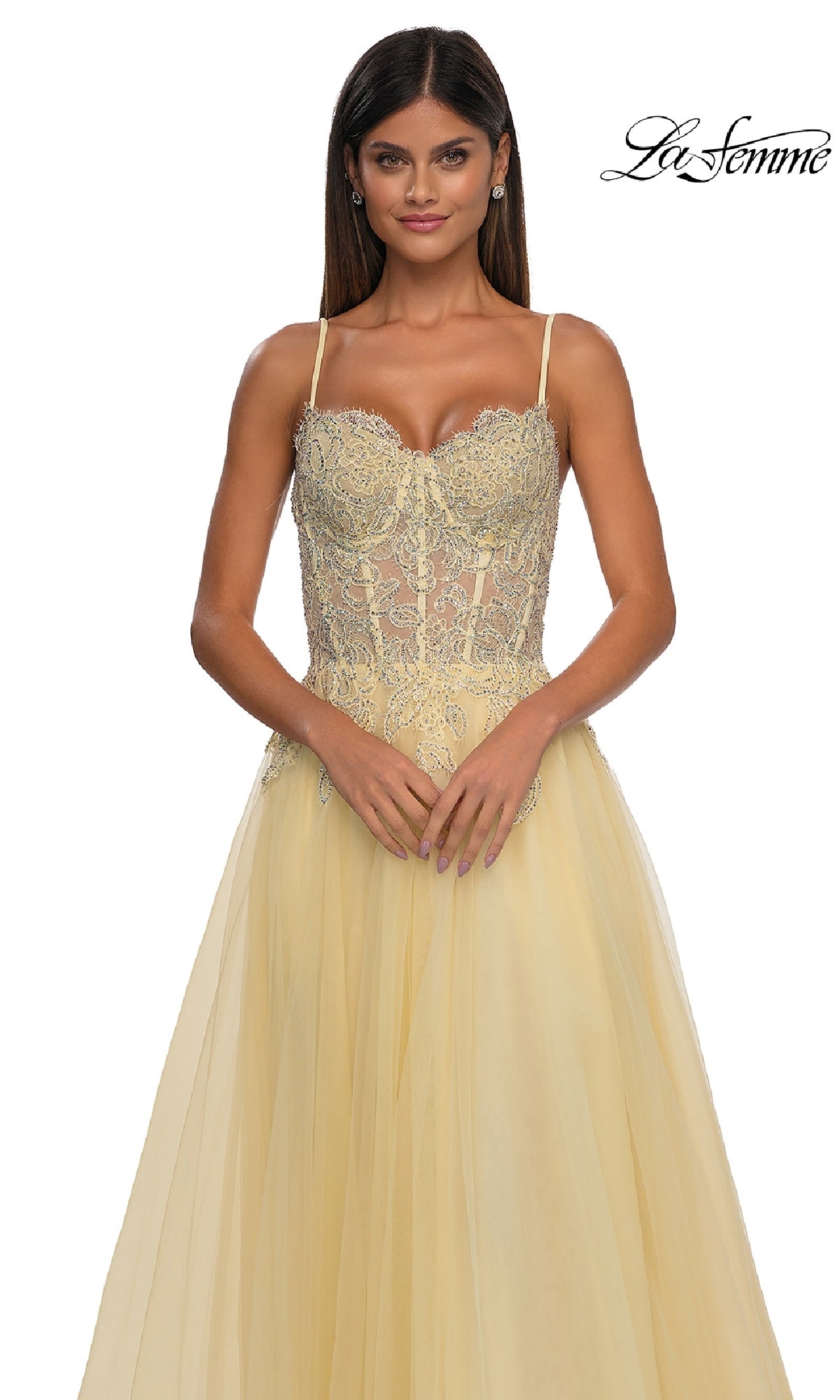 Woman wearing the La Femme 32646 Long Prom Ball Gown with Pockets, featuring a light yellow hue, lace-detailed fitted bodice, and thin straps, standing against a white background.