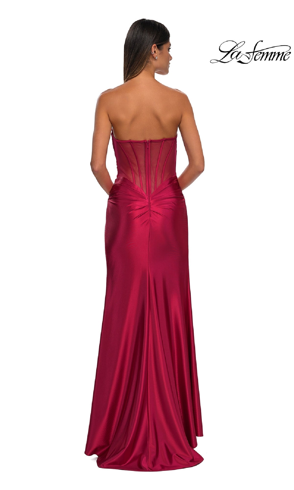 A woman is photographed from behind in the La Femme 32649 Sheer-Back Strapless Prom Gown, featuring a sweetheart neckline, sheer back panel, and elegant ruching, set against a white background.