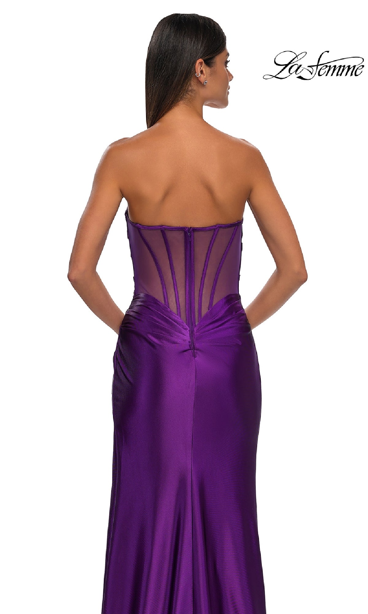 A woman models the Sheer-Back Strapless Prom Gown: La Femme 32649, featuring a sweetheart neckline, visible boning, and a sheer back panel, against a white background.