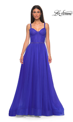 Woman wearing La Femme 32956, a floor-length royal blue A-line prom ball gown with thin straps, fitted corset bodice, and beaded waist; La Femme logo in the top right corner.