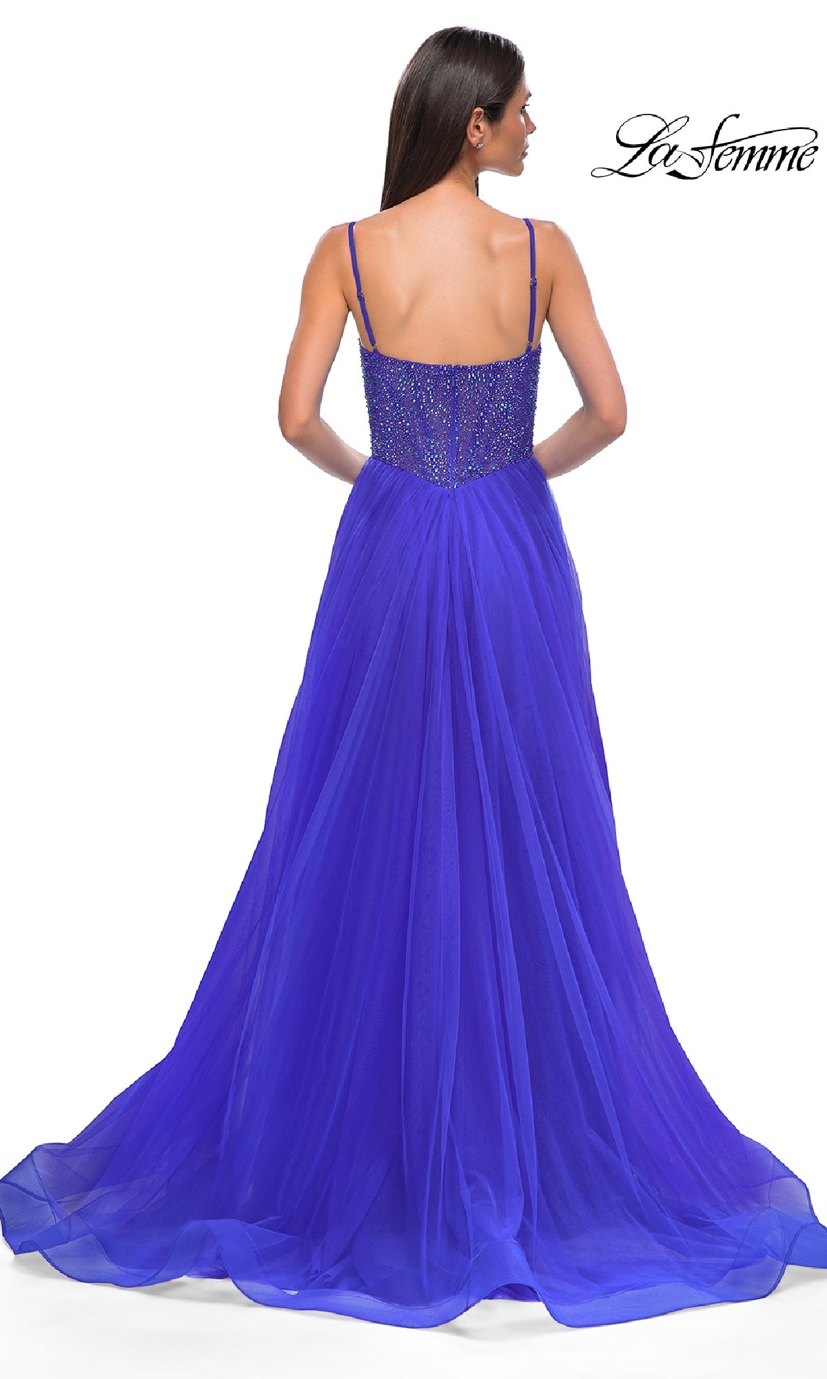 A woman in the Beaded-Bodice Long Prom Ball Gown La Femme 32668, featuring a floor-length royal blue a-line silhouette with thin straps, beaded v-neck bodice, and elegant tulle skirt, seen from the back. La Femme logo shown.