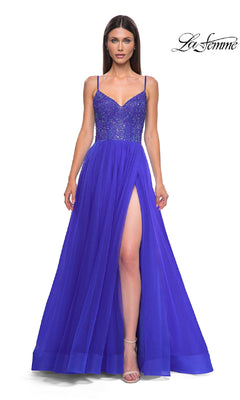 A woman wears the Beaded-Bodice Long Prom Ball Gown La Femme 32668, featuring a vibrant blue a-line silhouette, beaded v-neck bodice, thin straps, high slit, and flowing skirt. The La Femme logo is displayed in the top right corner.