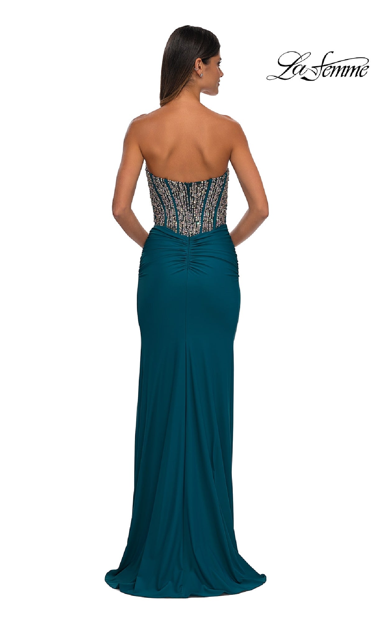 Woman models the Strapless Long Corset Prom Dress: La Femme 32669 in teal, featuring a beaded corset bodice, ruching, and a fitted silhouette. Seen from the back with the 