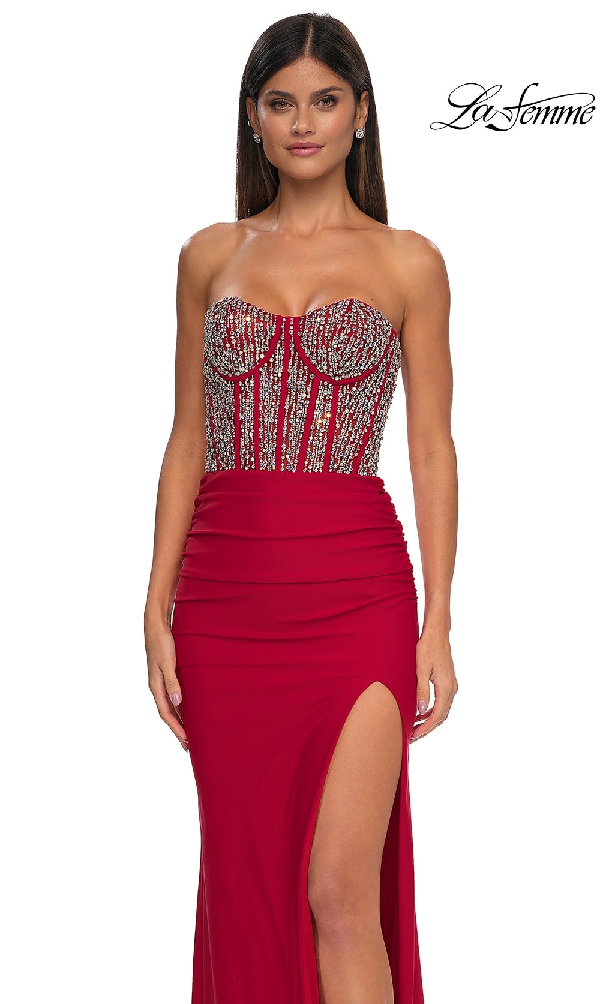 A woman wears the La Femme 32669 Strapless Long Corset Prom Dress in red, showcasing a beaded corset bodice and thigh-high slit, standing against a plain white background.