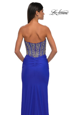 A woman is shown from the back wearing La Femme 32669, a strapless long royal blue prom dress with a beaded corset-style bodice.