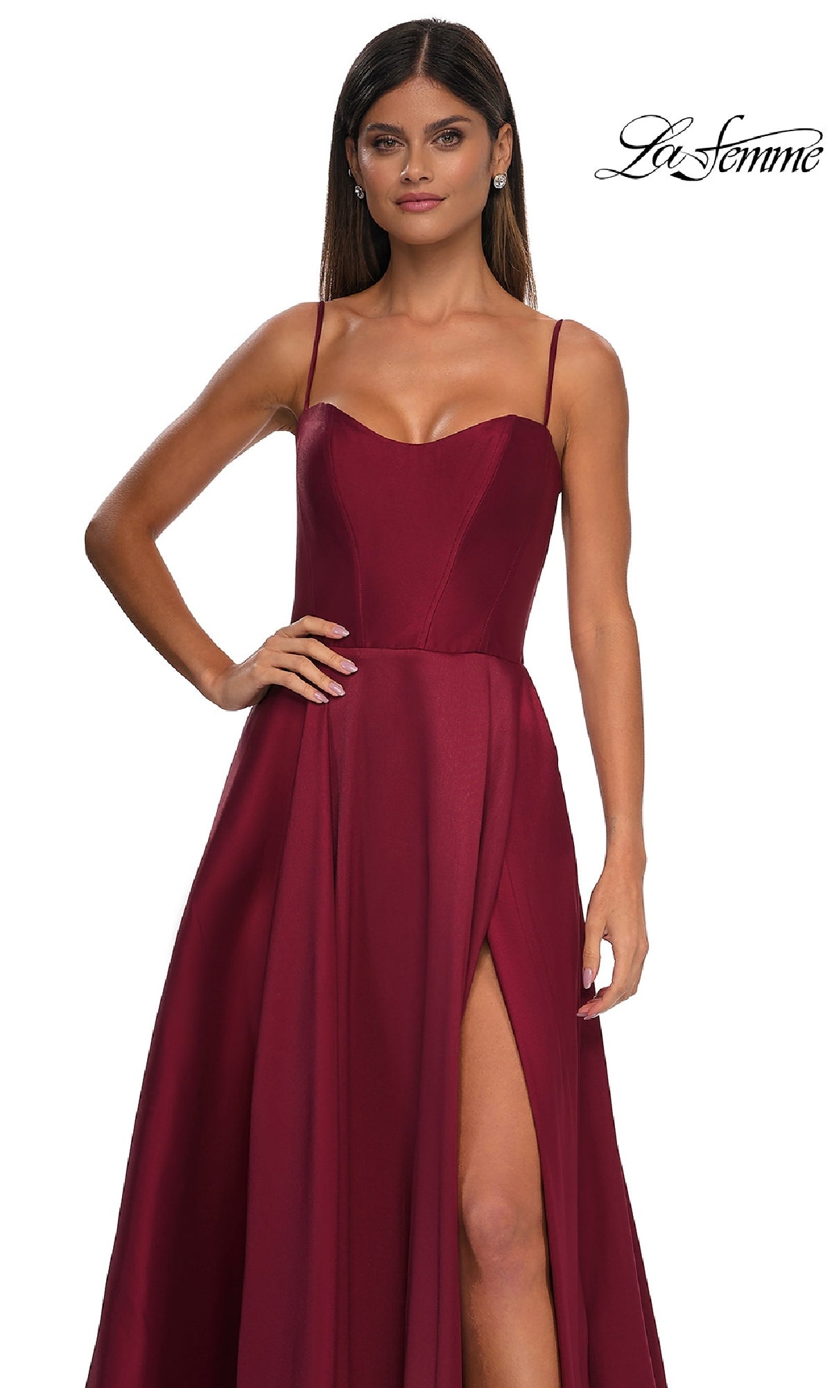 Woman in a sleeveless, floor-length burgundy Sheer-Corset Long A-Line Prom Gown (La Femme 32670) with spaghetti straps, sheer-back detail, and thigh-high slit against a white background.
