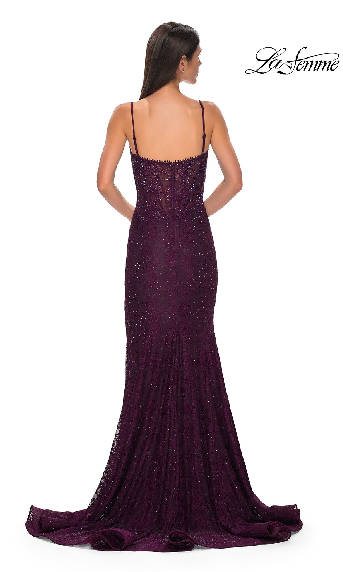 A woman faces away, wearing a floor-length dark purple La Femme 32671 prom dress with thin straps and a beaded-lace fitted mermaid corset silhouette. The brand name 