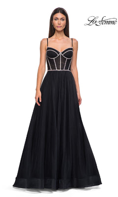 Woman in a black Long Corset Prom Ball Gown: La Femme 32675 with a sheer corset-style bodice and thin straps, standing against a white backdrop. "La Femme" logo in the top right highlights this elegant formal dress.