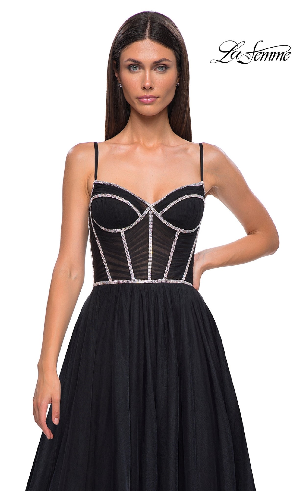 A woman models the Long Corset Prom Ball Gown (La Femme 32675), featuring thin straps, sheer panels, and silver trim; 