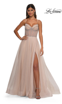 A woman models the La Femme 32675 long corset prom ball gown—a blush pink, sleeveless formal dress with thin straps, a high leg slit, and an a-line silhouette. The La Femme logo appears in the top right corner.