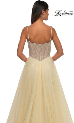 Woman facing away in a light yellow Long Corset Prom Ball Gown, La Femme 32675, featuring a strapless sheer structured bodice; "La Femme" logo appears in the top right corner.