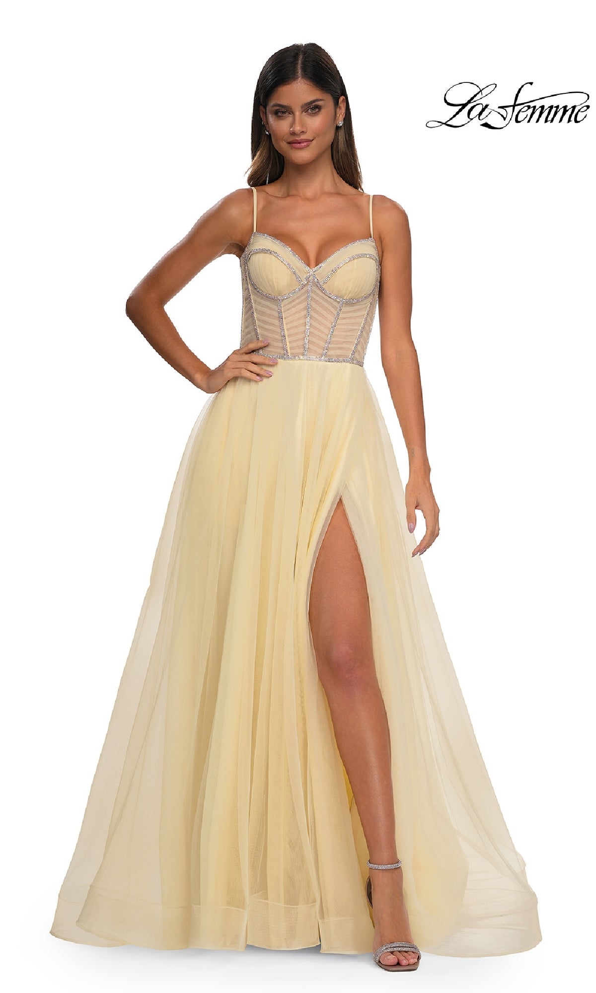 Woman models a pale yellow La Femme 32675 Long Corset Prom Ball Gown featuring a sheer structured bodice, spaghetti straps, and a high slit skirt. The elegant floor-length dress exudes timeless sophistication. La Femme logo appears top right.