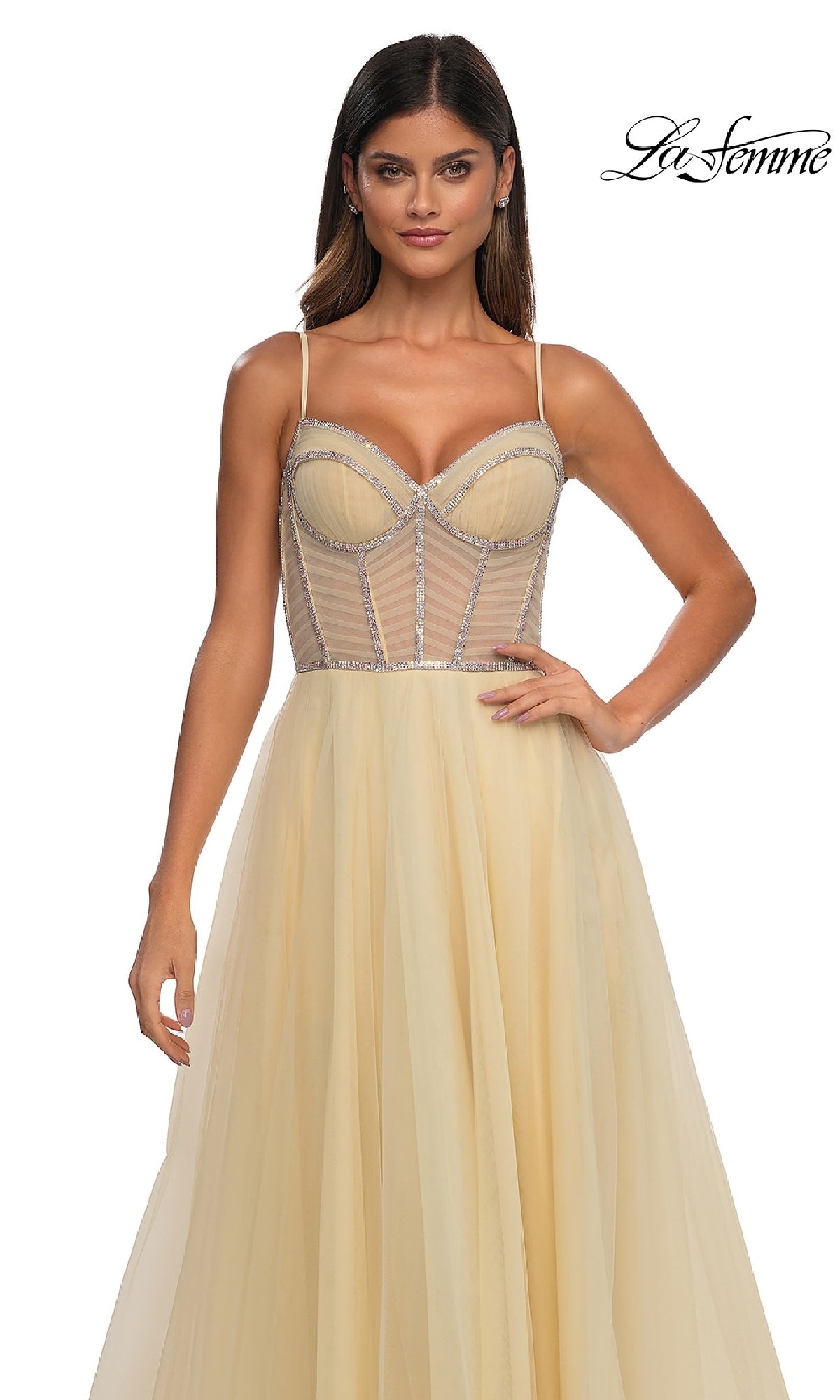 A woman poses against a white background wearing the La Femme 32675, a yellow tulle A-line prom ball gown featuring a sheer, structured corset bodice and thin straps.
