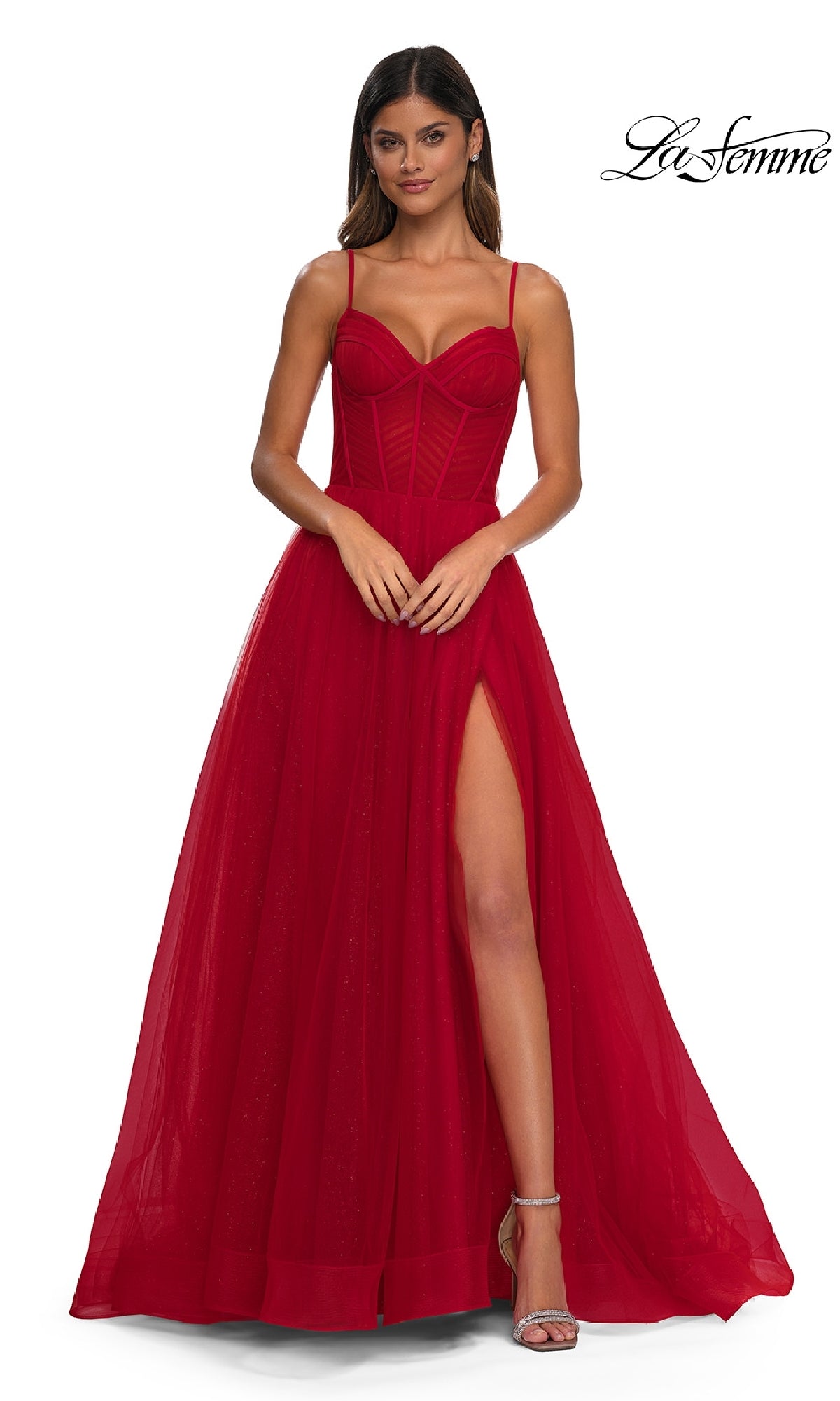 Woman wearing the Long Corset A-Line Prom Dress: La Femme 32680, a sleeveless, floor-length gown with a fitted bodice, thin straps, and a high slit, standing against a white background.