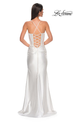 A woman stands facing away in the La Femme 32683 Lace-Up Long Satin Prom Dress, featuring a corset bodice, lace-up back, and thin crisscross straps. The "La Femme" logo appears in the top right corner.