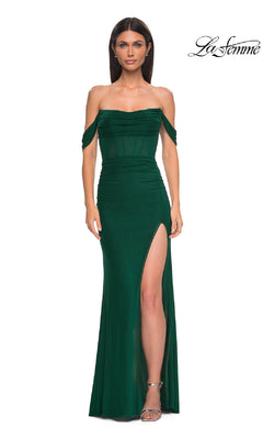 Woman poses in a dark green off-the-shoulder corset prom gown (La Femme 32684) with thigh-high slit, set against a white background. The "La Femme" logo appears in the top right, highlighting this elegant prom dress.