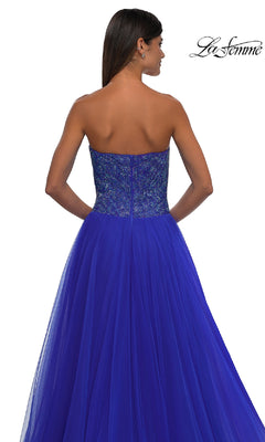 A woman models the La Femme 32690: a strapless long prom ball gown with a beaded sweetheart bodice and tulle skirt. The La Femme logo appears in the upper right corner.