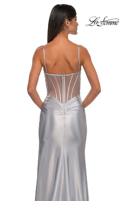 A woman faces away wearing the La Femme 32691 Long Satin Corset Prom Dress, featuring silver satin, spaghetti straps, and a sheer beaded corset bodice. The "La Femme" logo appears in the top right corner.