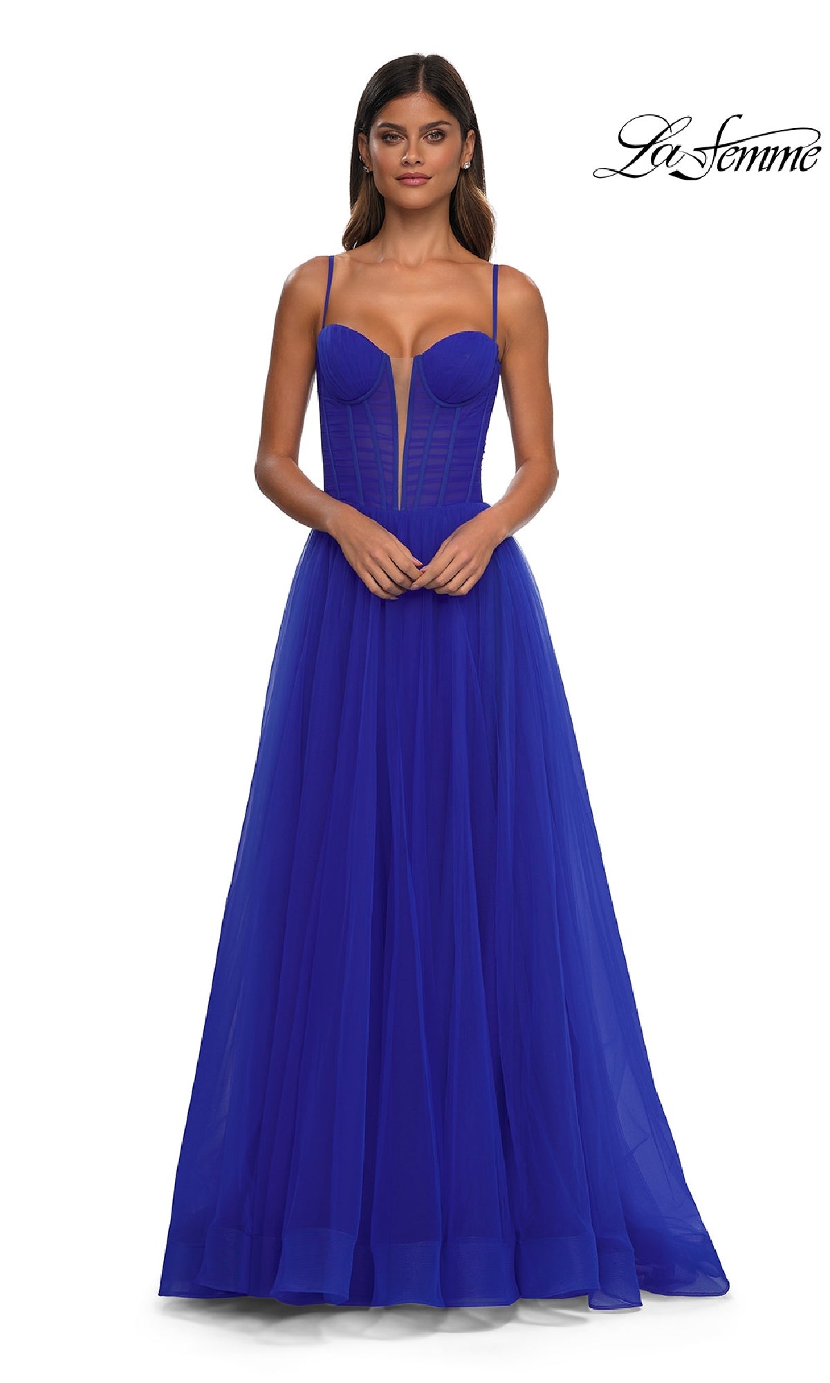 A woman wears the La Femme 32700 Tulle Prom Ball Gown with Pockets, featuring a vibrant royal blue hue, fitted bodice, thin straps, and a full A-line skirt. The La Femme logo is shown in the top right corner.