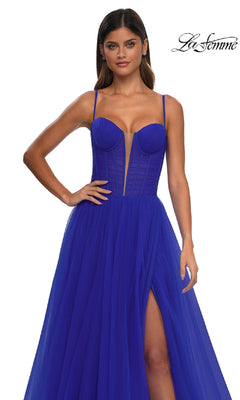 Woman wearing the Tulle Prom Ball Gown with Pockets, La Femme 32700—featuring a deep blue hue, sleeveless design, sheer corset bodice, thigh-high slit, elegant mesh details; "La Femme" logo appears top right.