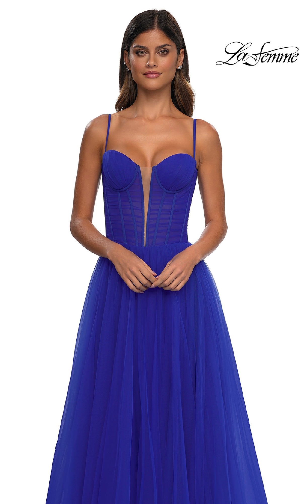 A woman models the La Femme 32700 tulle prom ball gown with pockets, featuring an a-line skirt, thin straps, structured bodice, and sheer paneling, set against a white background.