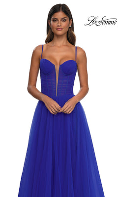 A woman models the La Femme 32700 tulle prom ball gown with pockets, featuring an a-line skirt, thin straps, structured bodice, and sheer paneling, set against a white background.