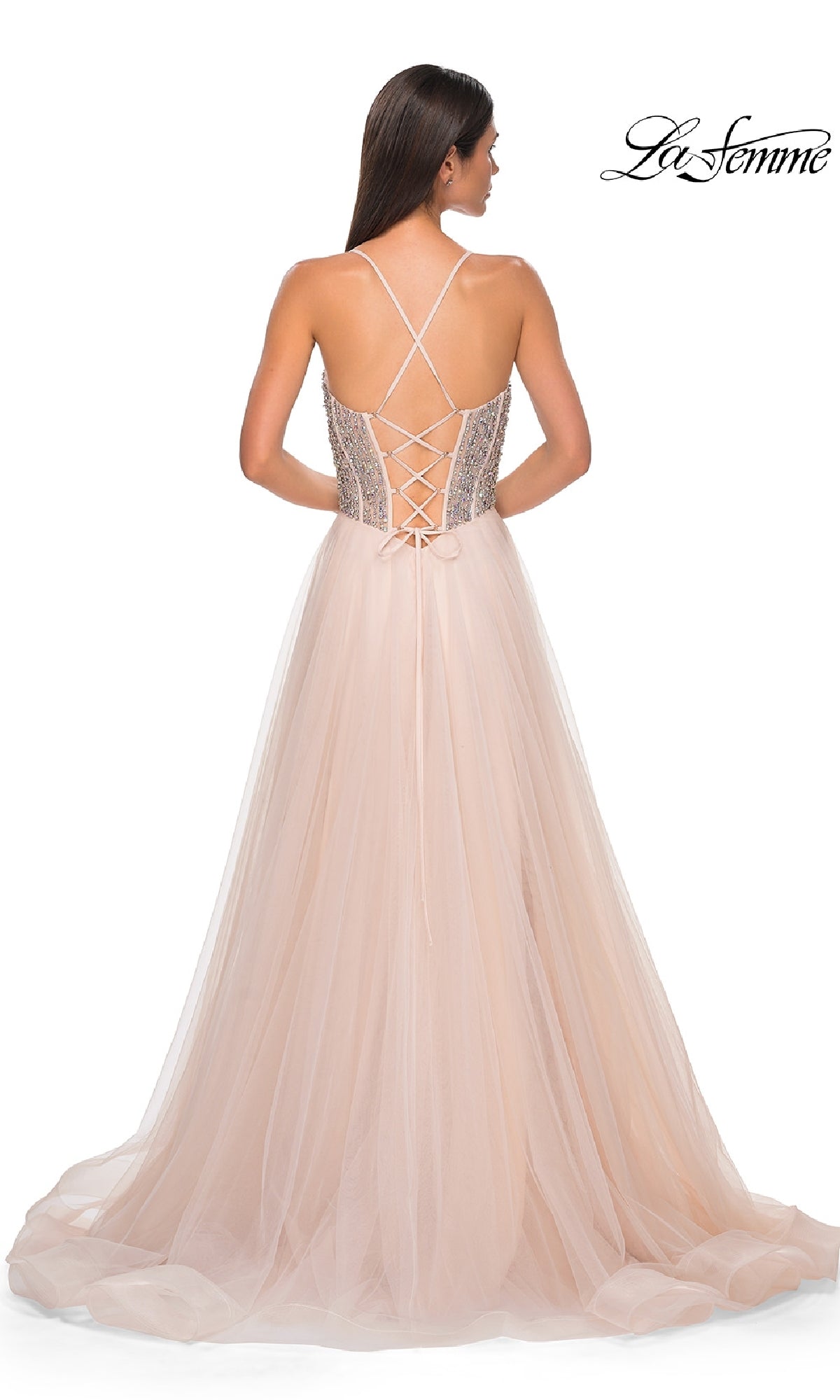 Woman in a blush pink tulle Beaded-Corset Long Prom Dress (La Femme 32703) with lace-up back and thin crisscross straps, viewed from behind. 