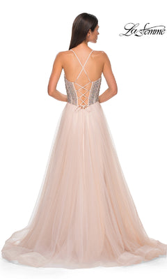 Woman in a blush pink tulle Beaded-Corset Long Prom Dress (La Femme 32703) with lace-up back and thin crisscross straps, viewed from behind. "La Femme" logo displayed in the top right corner.