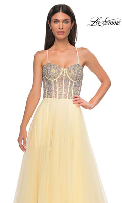 A woman models the La Femme 32703 Beaded-Corset Long Prom Dress in pale yellow, featuring a rhinestone-beaded corset bodice with thin straps, shown against a plain white background.