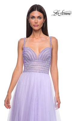 A woman in the La Femme 32714 Rhinestone-Bodice Prom Ball Gown—a lavender, long tulle A-line dress with a beaded bodice—stands before a white background featuring the “La Femme” logo.