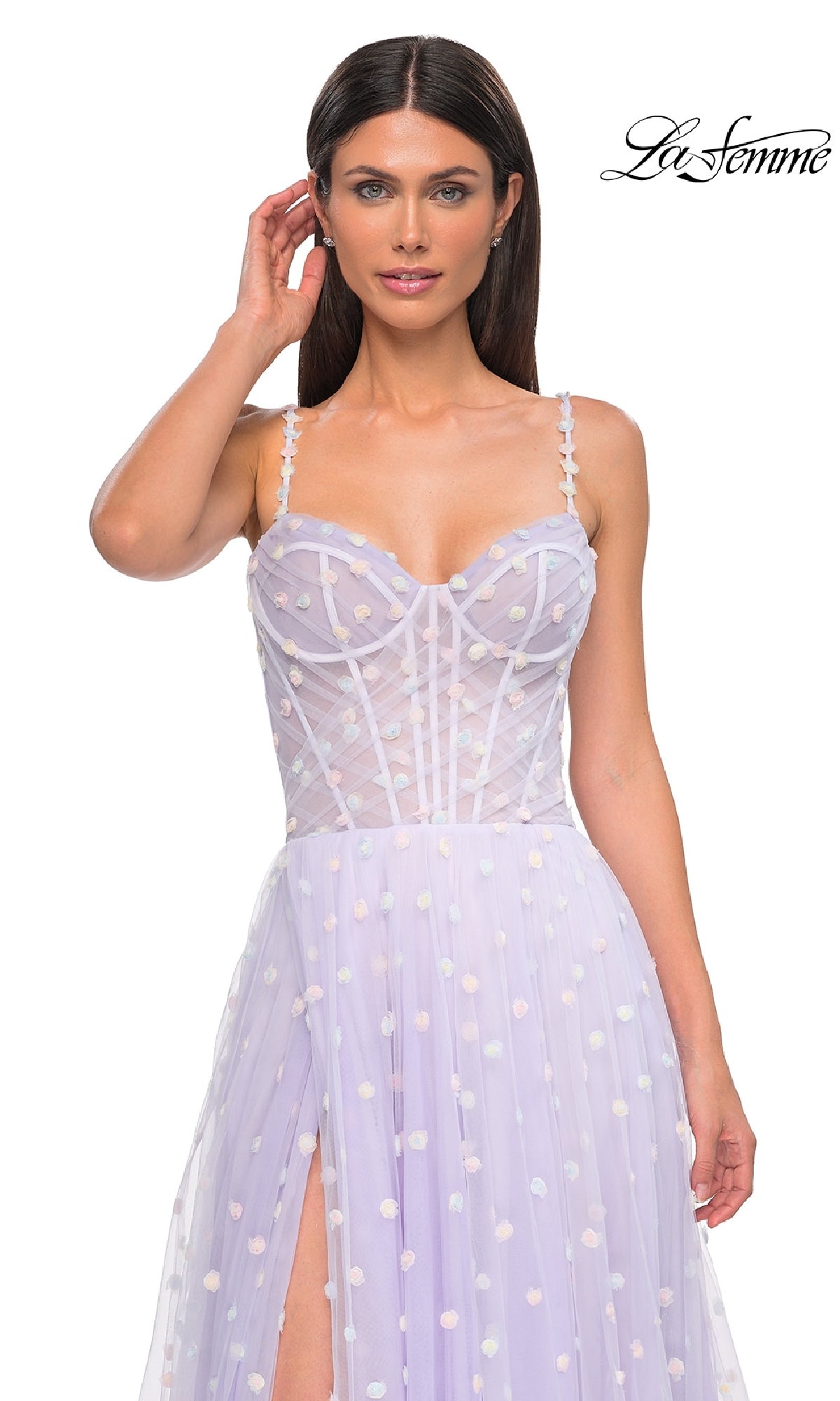Woman wearing the Polka-Dot Long Prom Ball Gown: La Femme 32716, featuring light purple polka dots, spaghetti straps, a corset-style bodice, and a thigh-high slit, posing with one hand near her head.