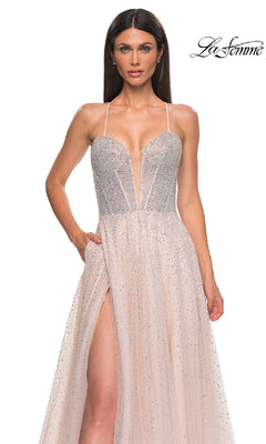 A woman wears the Lace-Up Beaded Long Prom Ball Gown: La Femme 32725, featuring sparkling beads, thin straps, a deep neckline, and a high slit, standing against a plain white background with the La Femme logo in the top right corner.