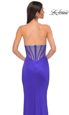 Woman wearing the Bead-Trimmed Strapless Prom Dress: La Femme 32733—a fitted royal blue gown with a beaded sweetheart neckline and sheer back panel—standing against a white background.