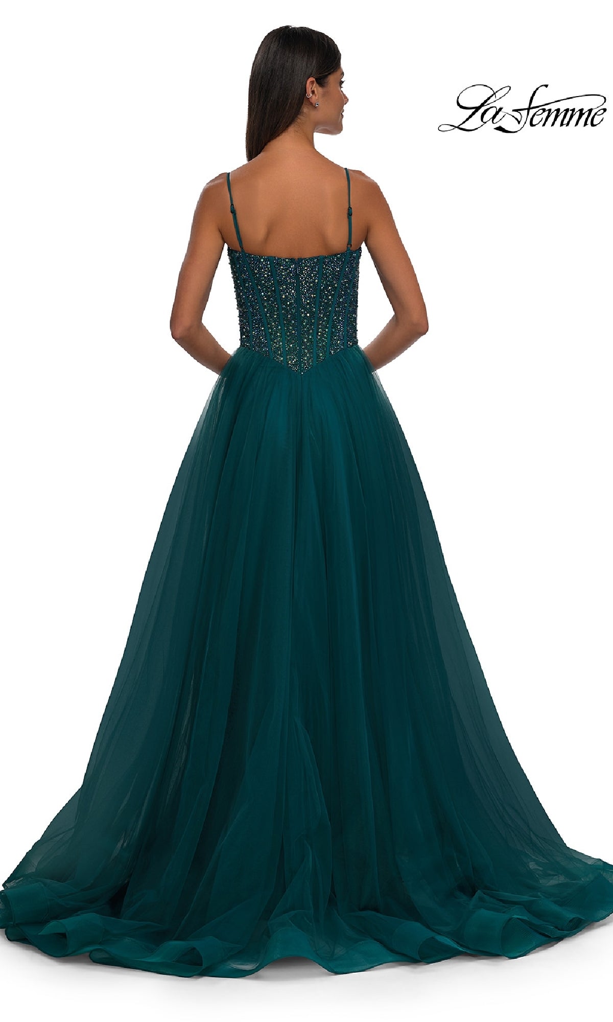 Woman in a dark teal La Femme 32754 prom dress with a fitted, beaded bodice and tulle skirt, facing away. 