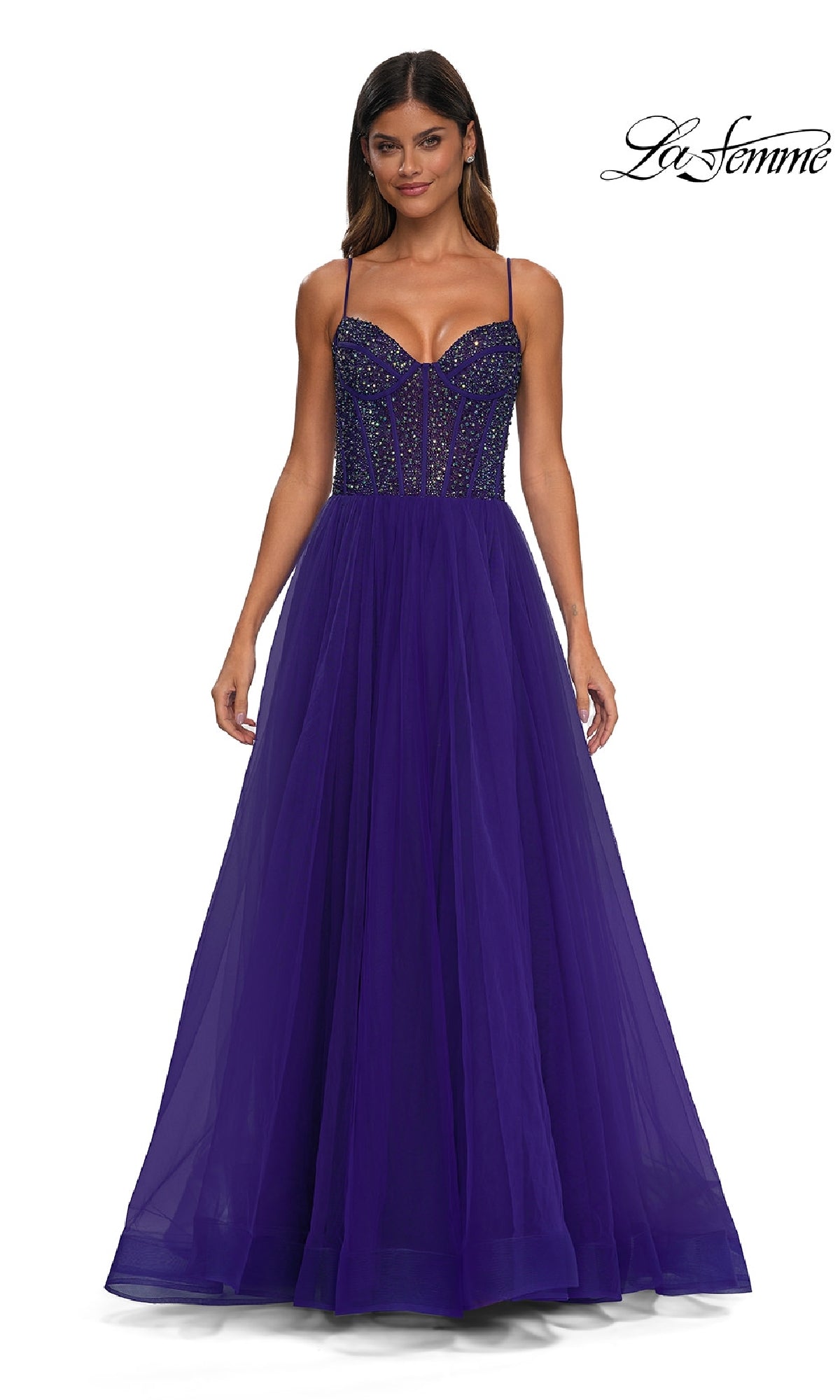 A woman wearing the Beaded-Bodice Long Prom Dress (La Femme 32754), featuring a floor-length deep purple design with thin straps, a sequin-embellished structured bodice, and a flowing tulle skirt.