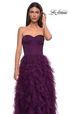 A woman wears the Strapless Long Ruffled Prom Dress: La Femme 32760 in deep purple, with a corset-style bodice and layered skirt. The "La Femme" logo is visible in the top right corner.