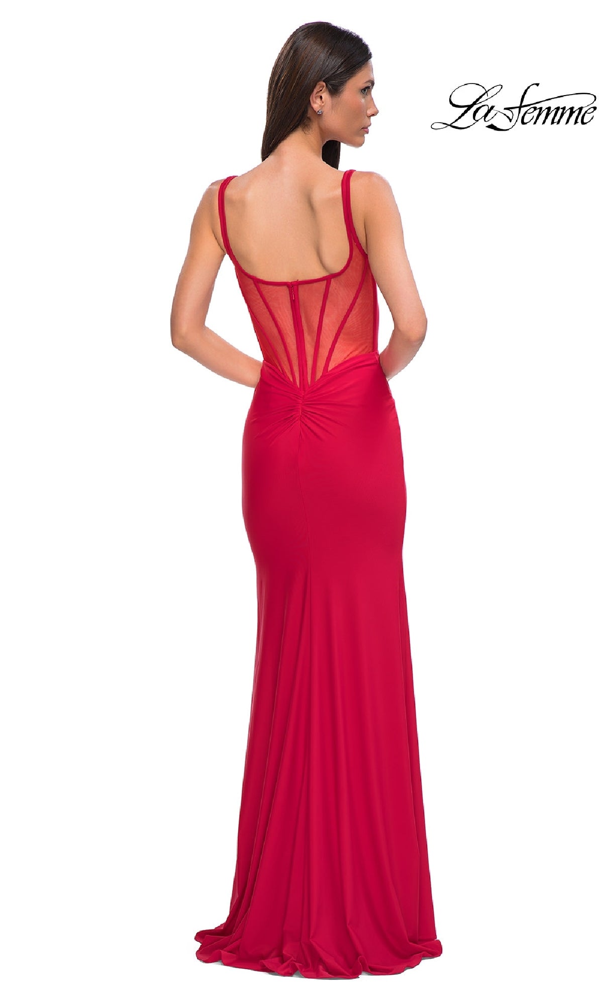 Woman wearing a floor-length, fitted red Plunging V-Neck Long Prom Dress: La Femme 32763 with sheer back and thin straps, facing away from the camera. 
