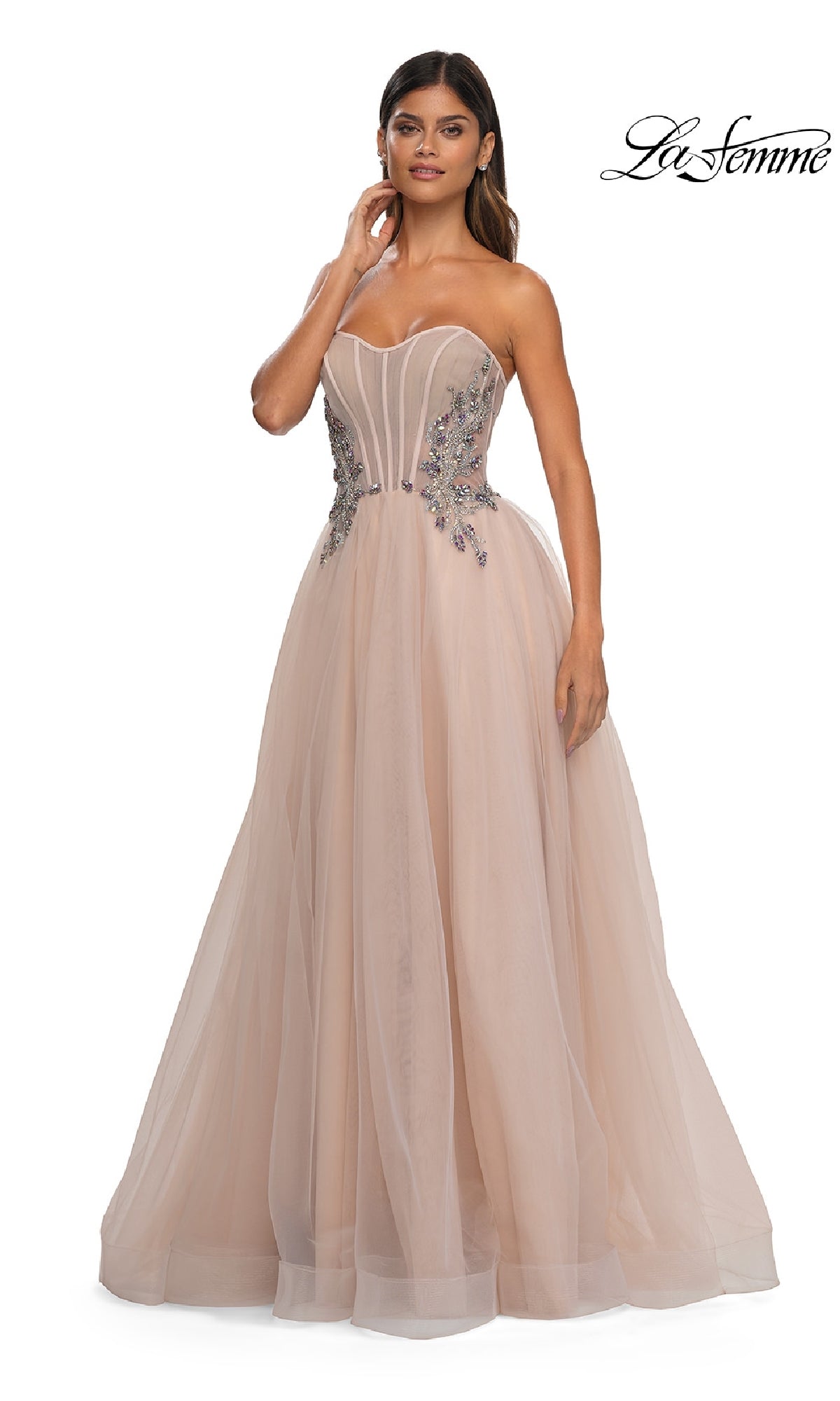 A woman wears the La Femme 32767 strapless long prom ball gown, featuring a blush pink fitted bodice with floral embellishments and a full tulle skirt for an elegant A-line formal look.