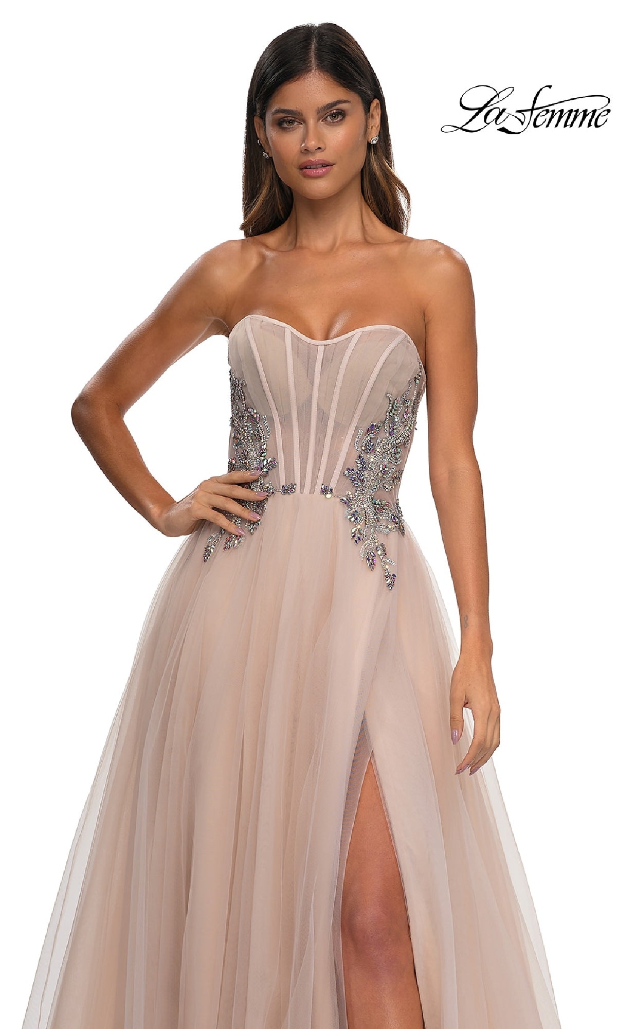 A woman wears the La Femme 32767 Strapless Long Prom Ball Gown, featuring a sheer bodice, beaded embellishments, and a thigh-high slit, standing against a plain white background.