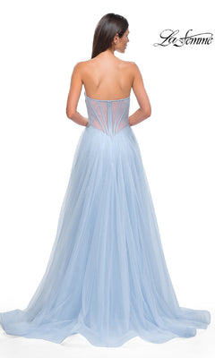A woman stands with her back to the camera in a light blue tulle Strapless Long Prom Ball Gown, La Femme 32767, featuring a semi-sheer corset back. The "La Femme" logo appears at the top right corner.