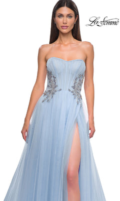 A woman models the La Femme 32767 strapless long prom ball gown, featuring silver embellishments and a thigh-high slit, set against a white background with the "La Femme" logo in the top right corner.