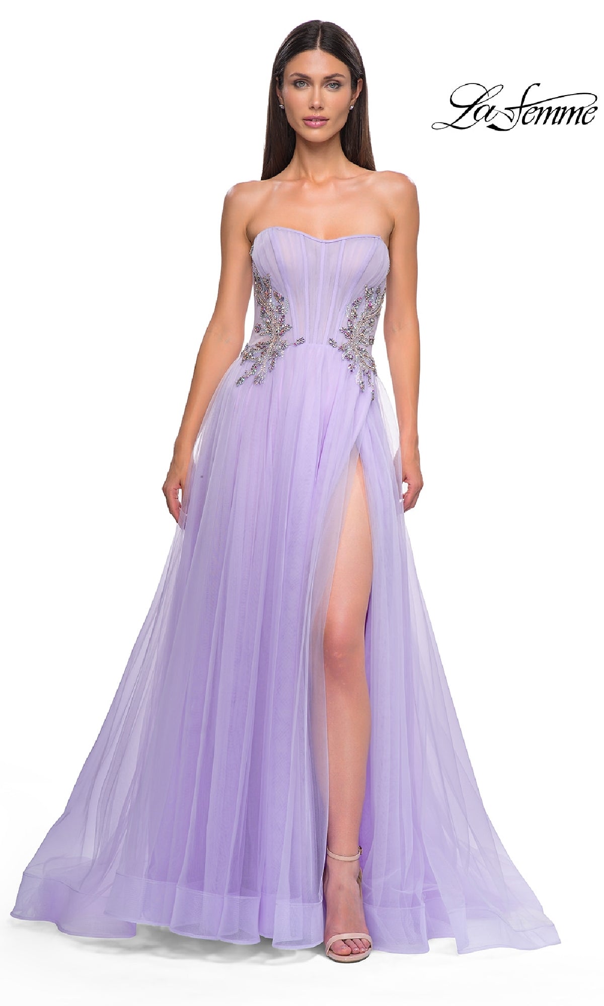 A woman models the Strapless Long Prom Ball Gown: La Femme 32767 in light purple, with floral embellishments, high slit, tulle skirt, and beaded corset bodice—an elegant style against a white background.