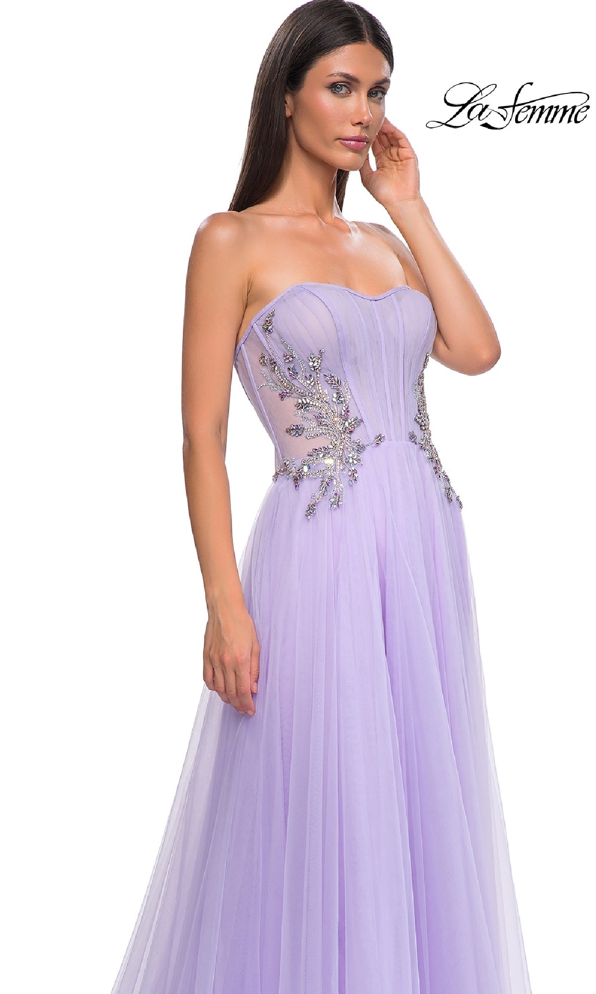 Woman wearing the Strapless Long Prom Ball Gown: La Femme 32767 in lavender, featuring beaded bodice embellishments and sheer side detailing, standing against a white background.