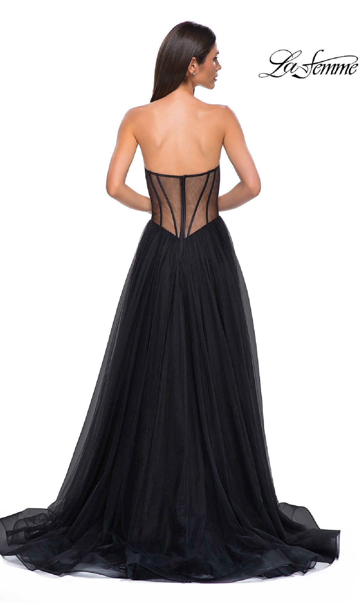 A woman wearing the La Femme 32771 black strapless long prom dress, featuring a sweetheart neckline, sheer corset-style back, and flowing tulle skirt, stands with her back to the camera.