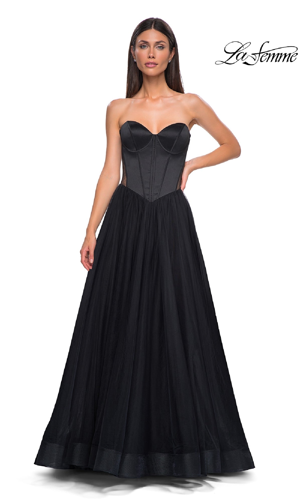 A woman stands against a white background wearing the La Femme 32771 Black Strapless Long Prom Dress, featuring a sweetheart neckline, corset-style bodice, and full tulle skirt. The 
