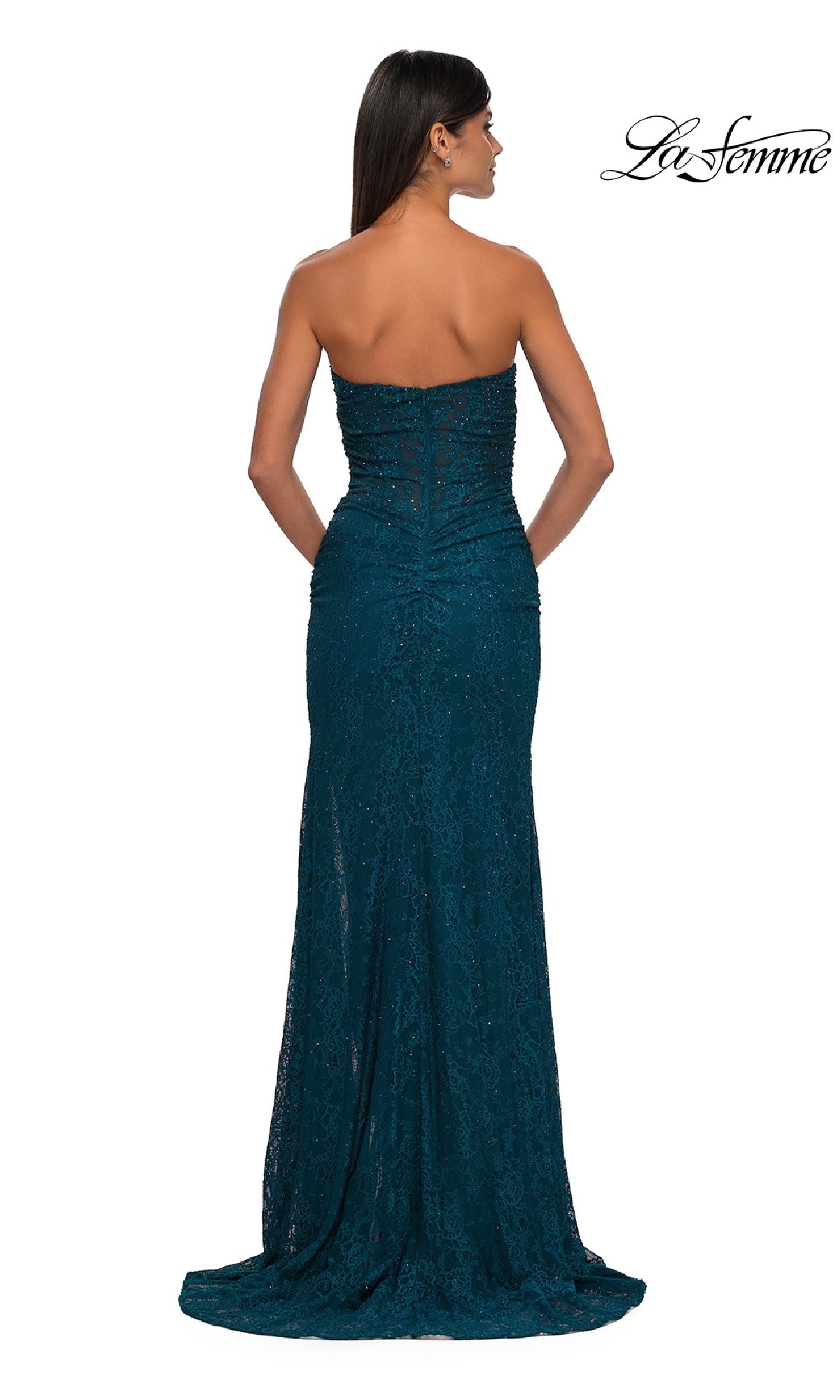 A woman faces away from the camera in a floor-length, teal, strapless beaded prom dress—La Femme 32773. The La Femme prom dress logo is displayed at the top right.