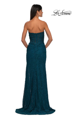 A woman faces away from the camera in a floor-length, teal, strapless beaded prom dress—La Femme 32773. The La Femme prom dress logo is displayed at the top right.
